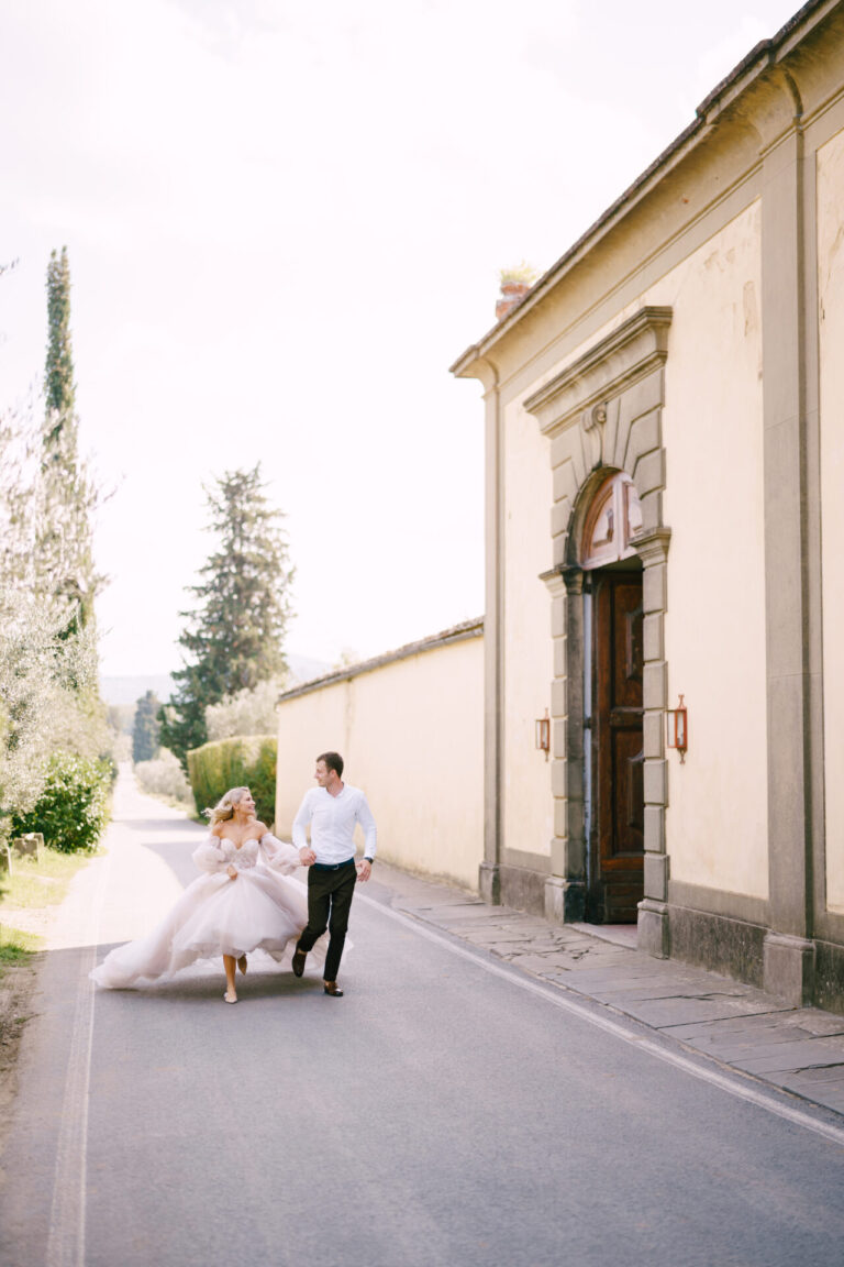Bride and groom running through streets of Florence