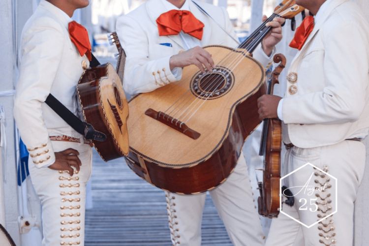 3 Mariachi band performers wearing white