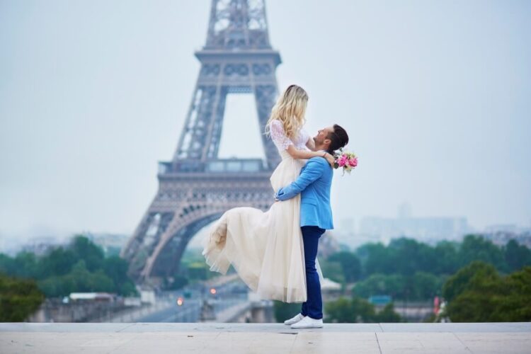 Groom lifting bride at Eiffel tower after eloping