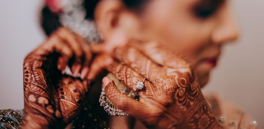beautiful bride with henna tattoos on hands with Aurus engagement ring on finger
