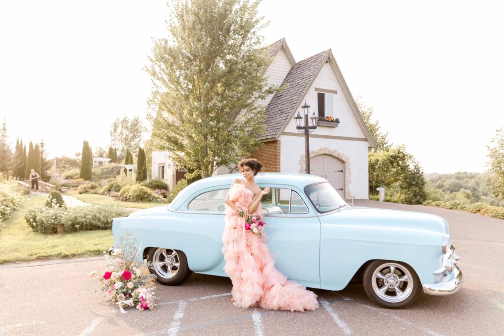 Beautiful bride with pink wedding dress and vintage blue car