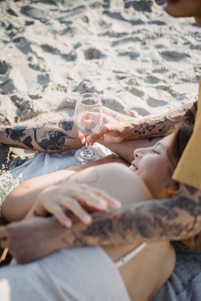Couple on beach enjoying luxury wedding gift -wine glasses