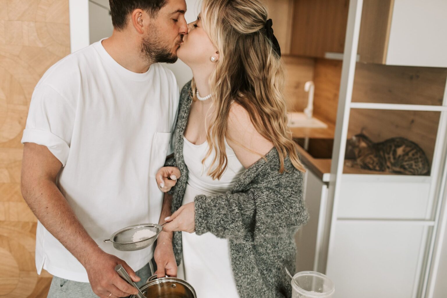 Couple kissing in kitchen while cooking together