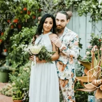 Groom wearing floral print suit with beautiful bride in outdoor boho portrait
