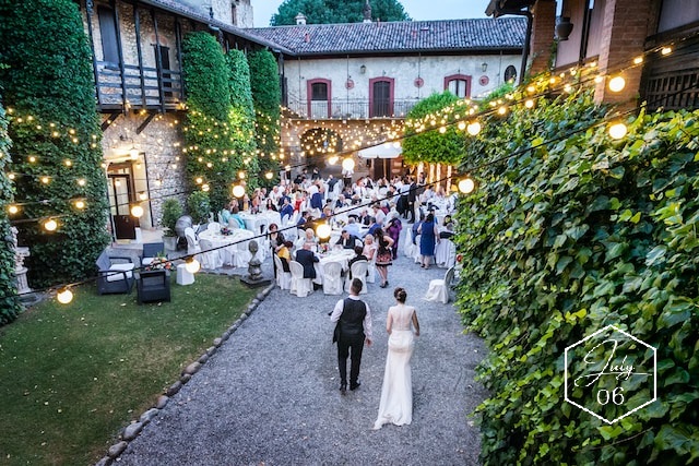 bride and groom entering courtyard wedding reception with outdoor wedding lighting