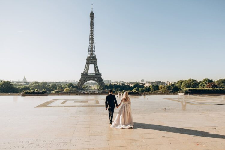bride and groom walking on plaza toward Eiffel Tower