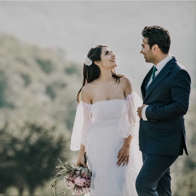 bride wearing off the shoulder wedding dress with groom outside